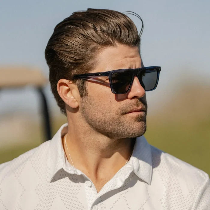 Indigo Blue Grain / Grey || Rectangular prescription sunglasses with blue acetate frame and grey lenses worn by man outdoors