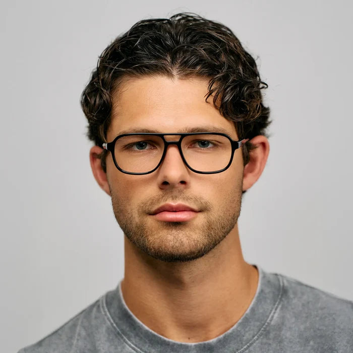 Black || Front view of aviator prescription glasses with thin black frame and flat top bridge worn by man indoors