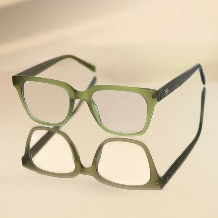 Frosted Khaki Green || Modern rectangular prescription glasses with green frame and integrated bridge resting on reflective surface