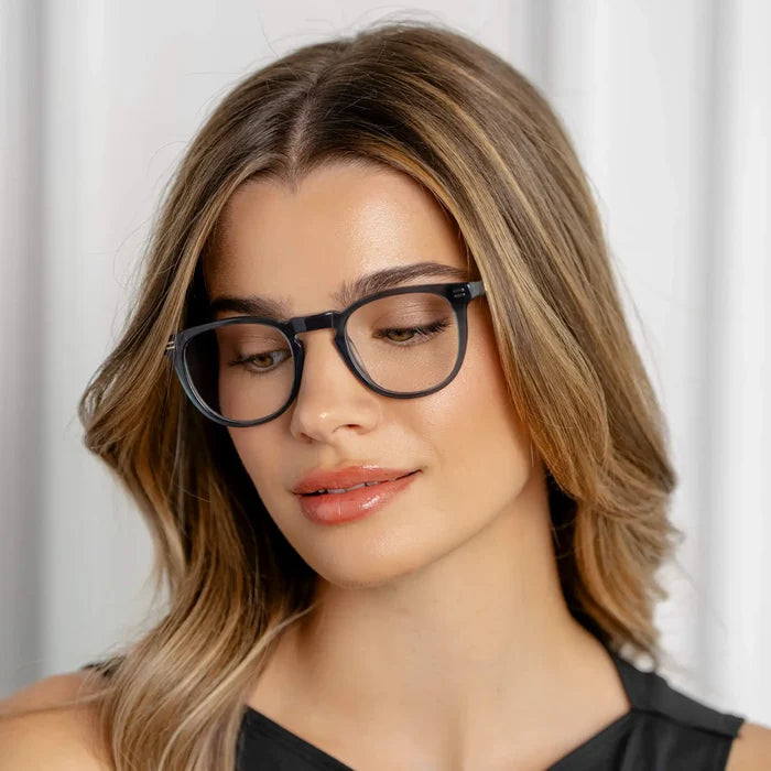 Crystal Steel Blue || Prescription eyeglasses with round frame and crystal steel blue acetate frame worn by woman looking down in natural light
