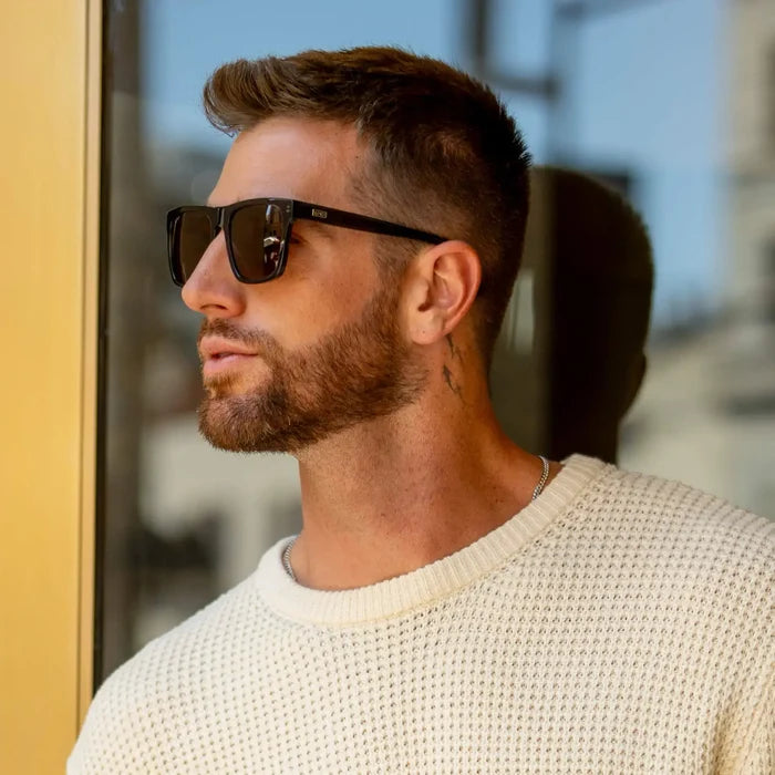 Crystal Carbon Grey / Amber || Square prescription sunglasses with grey acetate frame and amber lenses worn by man outdoors