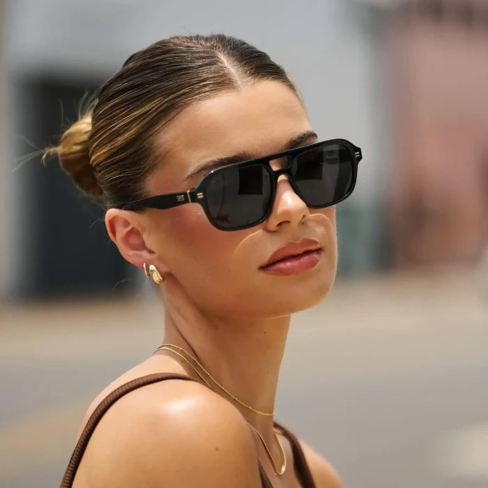 Black / Grey || Aviator prescription sunglasses with thick black acetate frame, wide keyhole bridge, and dark lenses worn by a woman outdoors