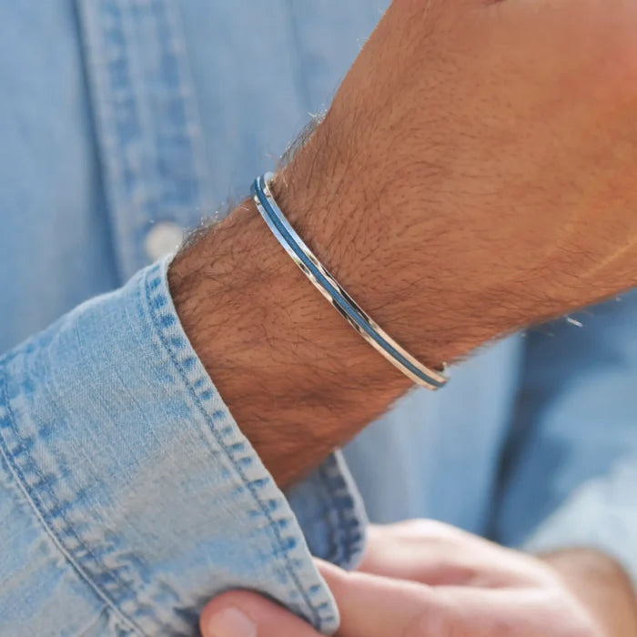 Silver / Denim Blue || Close up of a model wearing the Silver Stainless Steel Adjustable Cuff Bracelet with Blue Nylon Rope in natural lighting.