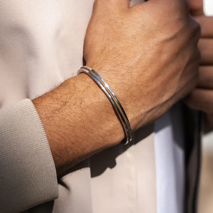 Desert Tan / Silver || Knox & Kent slim polished silver bangle worn on wrist over beige jacket sleeve in natural light
