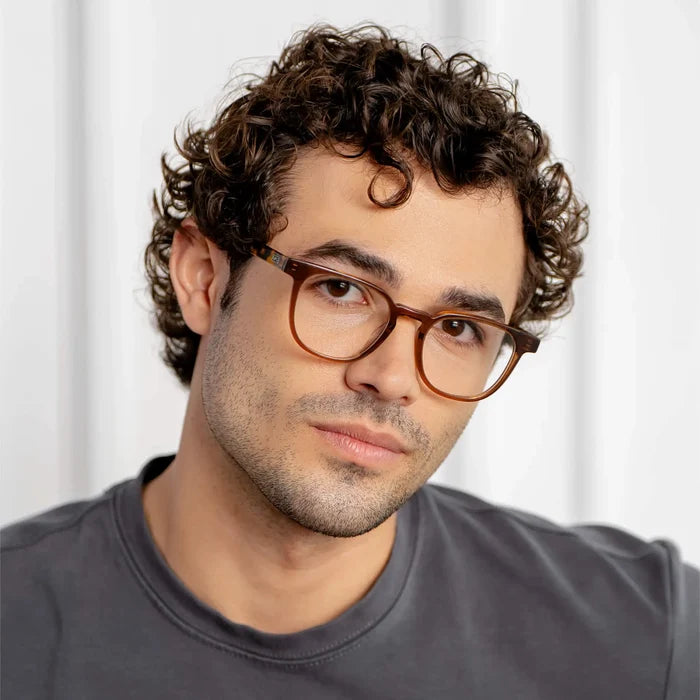 Crystal Brown || Rounded square prescription eyeglasses with crystal brown frame and clear lens worn by man with curly hair indoors