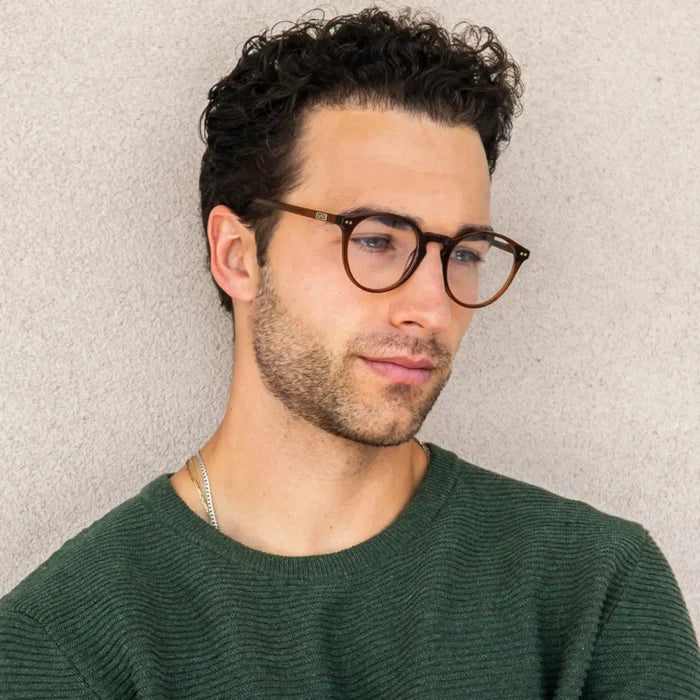 Crystal Chestnut Brown || Round prescription eyeglasses with thin acetate brown frame and keyhole bridge worn by man with curly hair