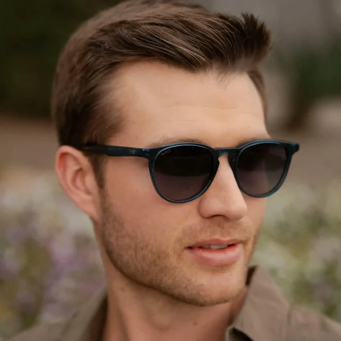 Crystal Cobalt / Grey || Round prescription glasses with blue acetate frame and keyhole bridge worn by man outdoors