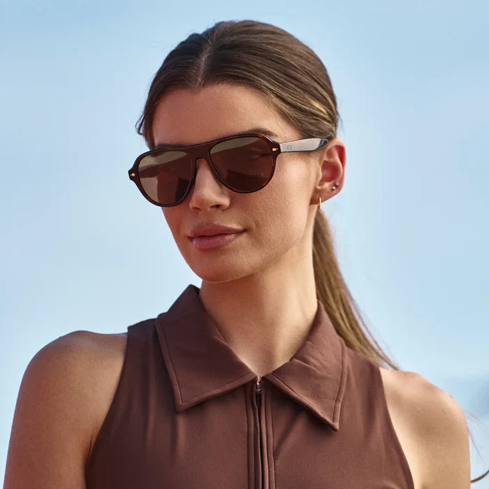 Woman wearing Rounded Aviator Sunglasses with Brown Tortoise Frame and Brown Lenses in natural light