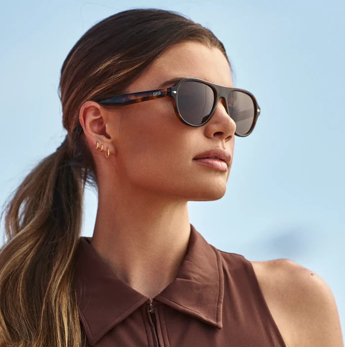 Brown Tortoise / Brown Lens || Woman wearing Rounded Aviator Sunglasses with Brown Tortoise Frame and Brown Lenses in natural light